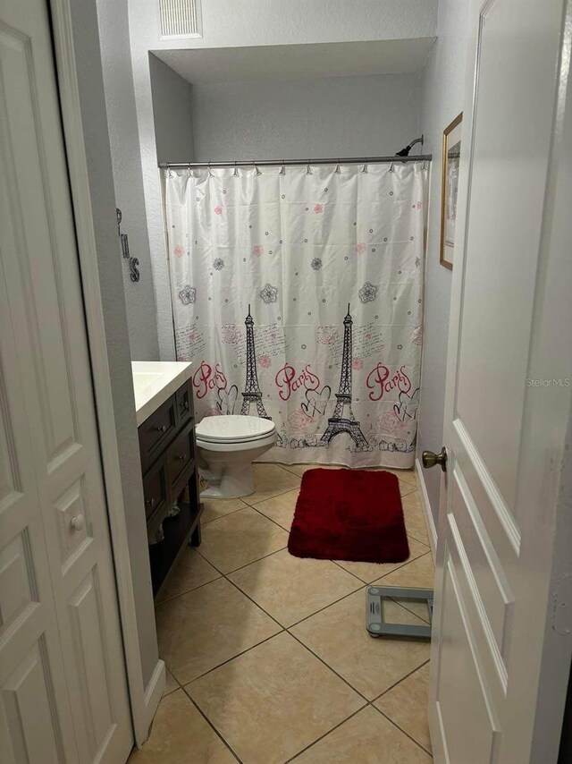 bathroom featuring vanity, tile flooring, and toilet