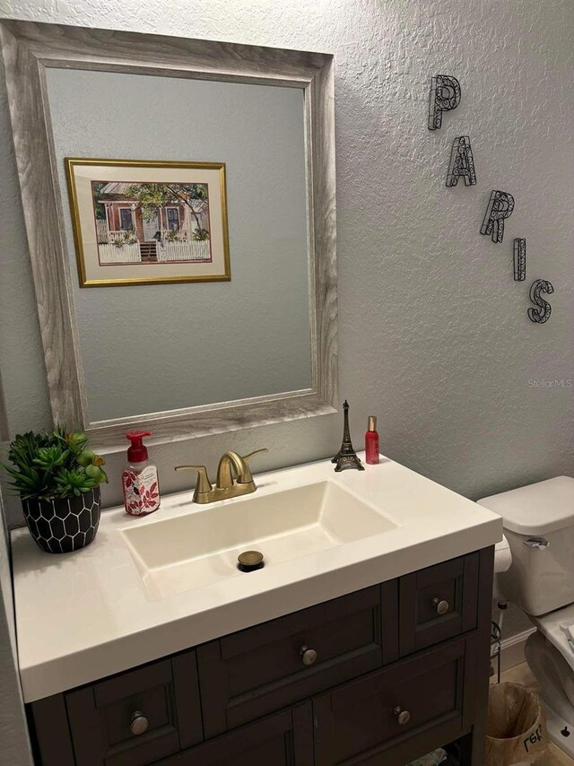 bathroom featuring toilet and vanity