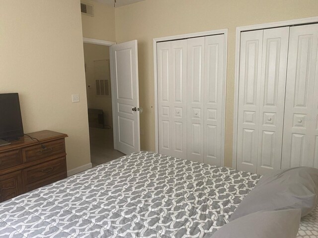 carpeted bedroom featuring two closets