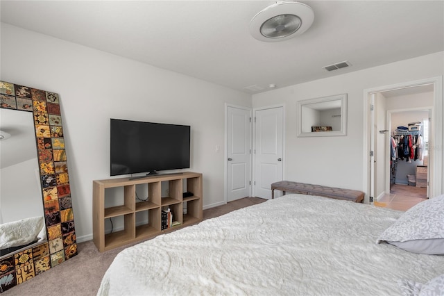 bedroom featuring baseboards, visible vents, and light colored carpet