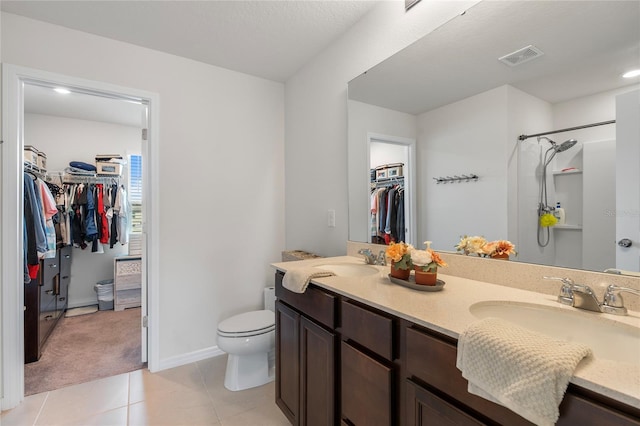 bathroom featuring tile patterned floors, a sink, a spacious closet, and double vanity