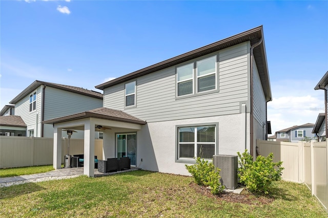 back of property featuring central AC unit, a lawn, a fenced backyard, ceiling fan, and a patio area