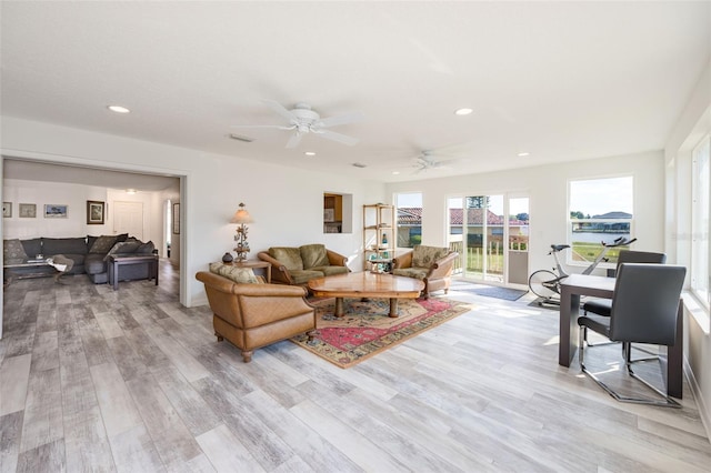 living room with light hardwood / wood-style floors and ceiling fan