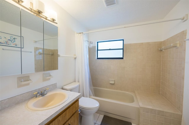 full bathroom featuring a textured ceiling, shower / bath combination with curtain, toilet, vanity, and tile patterned flooring