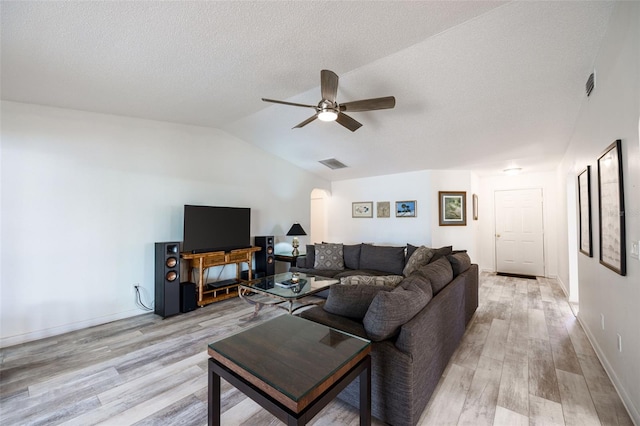 living room featuring ceiling fan, a textured ceiling, lofted ceiling, and light wood-type flooring