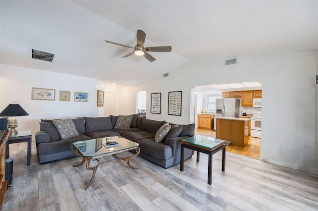 living room with lofted ceiling, light hardwood / wood-style flooring, and ceiling fan