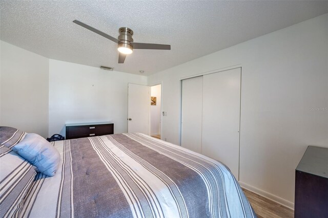 bedroom featuring a closet, ceiling fan, a textured ceiling, and hardwood / wood-style floors