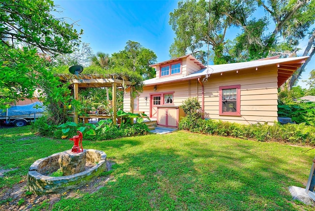 back of house featuring a pergola and a lawn