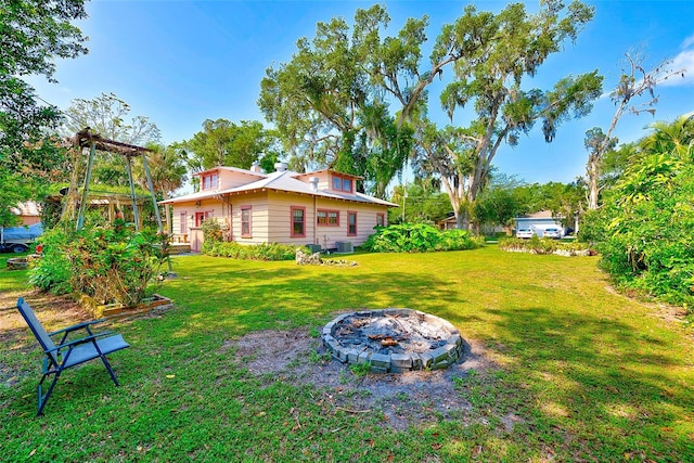 view of yard with cooling unit and a fire pit