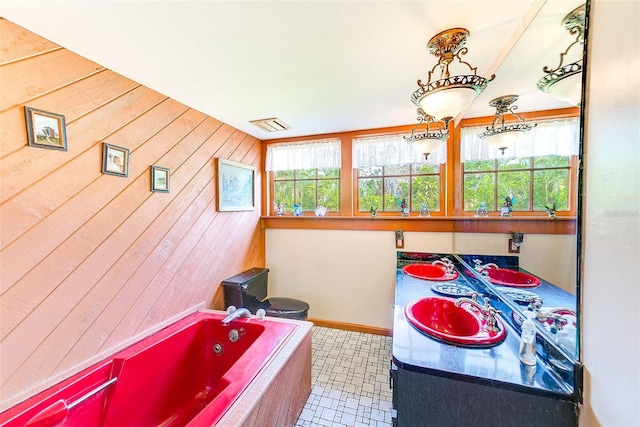 bathroom featuring vanity, a bathing tub, wood walls, and tile patterned flooring