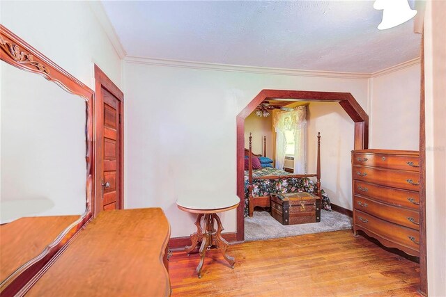 living area with hardwood / wood-style floors, a textured ceiling, and ornamental molding