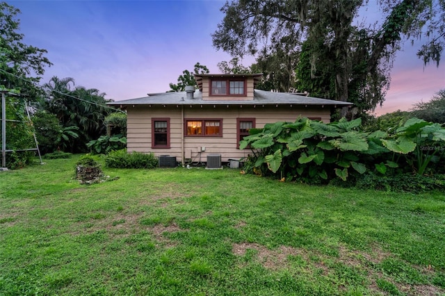 exterior space with cooling unit and a lawn