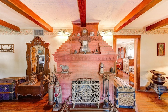 living room featuring ornamental molding, a textured ceiling, hardwood / wood-style flooring, and beamed ceiling