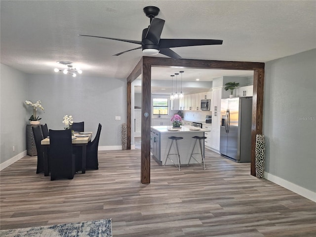 dining room featuring ceiling fan, a textured ceiling, and hardwood / wood-style flooring