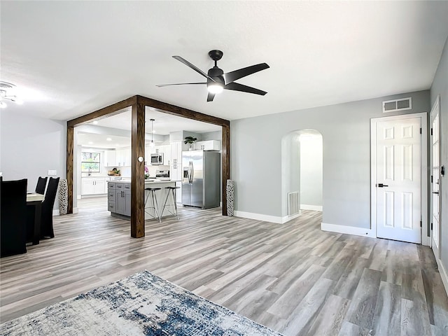 unfurnished living room with light wood-type flooring and ceiling fan