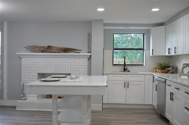 kitchen with dishwasher, light wood-type flooring, backsplash, white cabinets, and sink