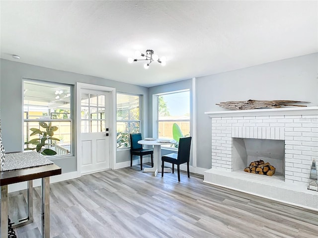 interior space featuring a fireplace, a notable chandelier, and light hardwood / wood-style flooring