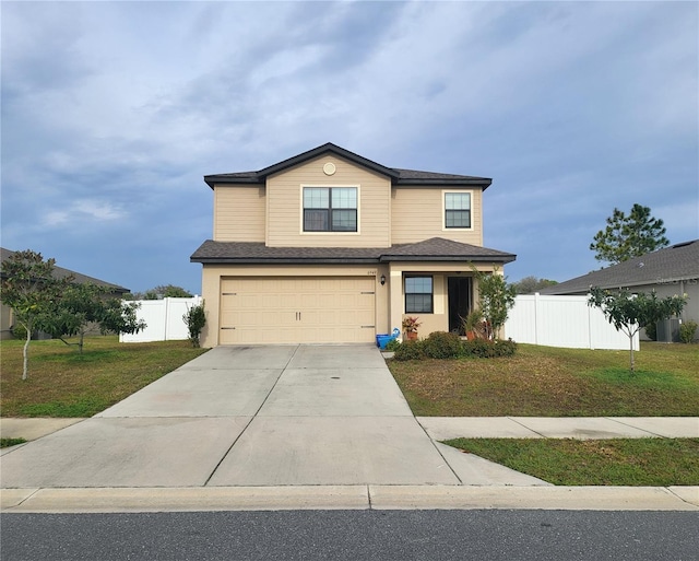 view of front of home featuring driveway, an attached garage, fence, and a front yard