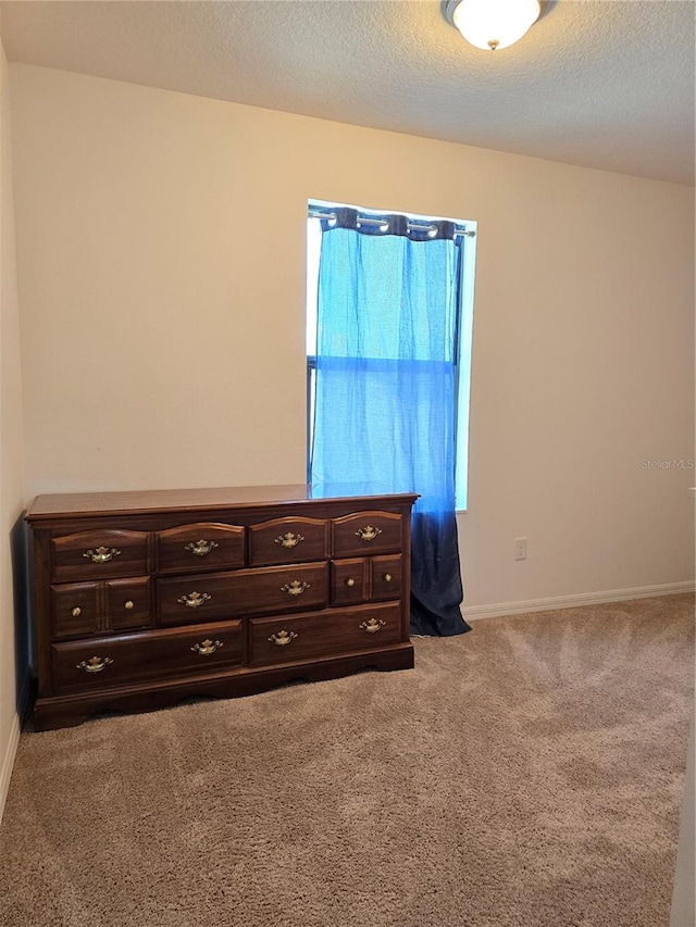 unfurnished bedroom with a textured ceiling and carpet floors