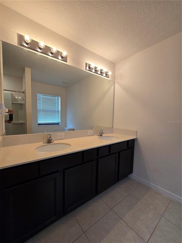 bathroom featuring walk in shower, tile patterned flooring, a textured ceiling, and vanity