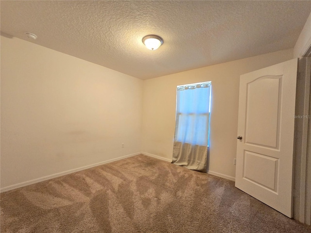 unfurnished room with a textured ceiling and carpet