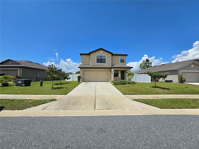 traditional-style home with an attached garage, fence, concrete driveway, and a front yard