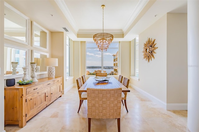 dining area featuring an inviting chandelier, a healthy amount of sunlight, a tray ceiling, and crown molding