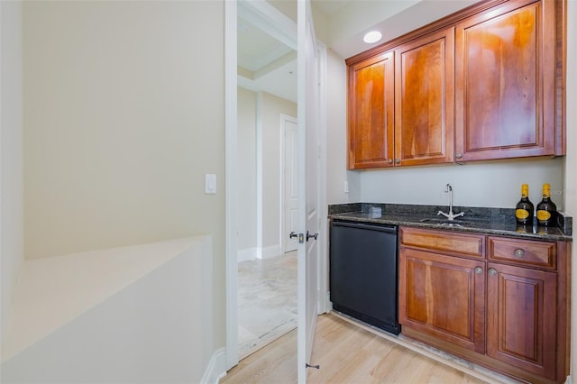 kitchen with sink, black dishwasher, dark stone counters, and light wood-type flooring