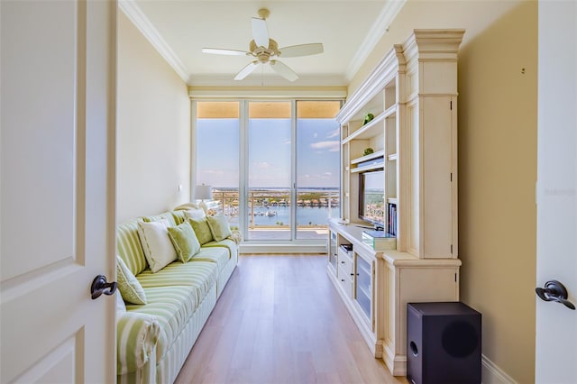 interior space featuring crown molding, light wood-type flooring, and ceiling fan