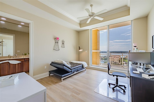 home office featuring ornamental molding, a tray ceiling, light hardwood / wood-style floors, and ceiling fan