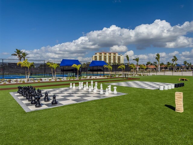 surrounding community featuring a tennis court, a yard, and fence