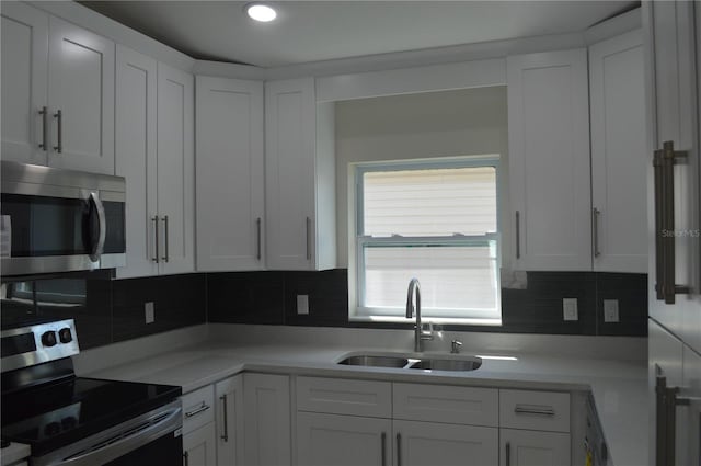 kitchen with white cabinets, tasteful backsplash, and appliances with stainless steel finishes