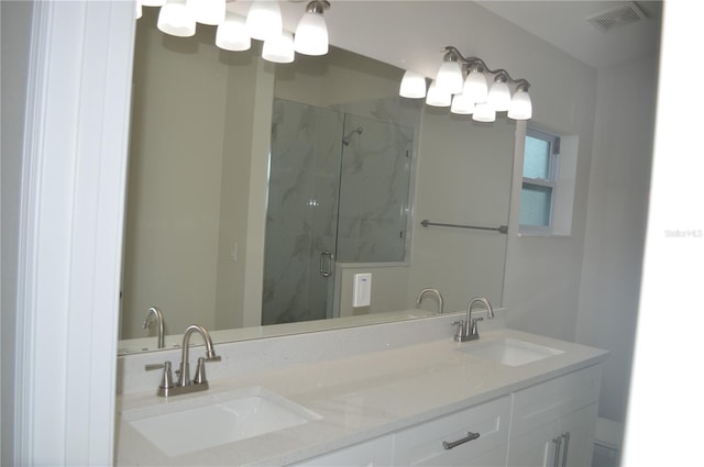 bathroom with an enclosed shower and double sink vanity