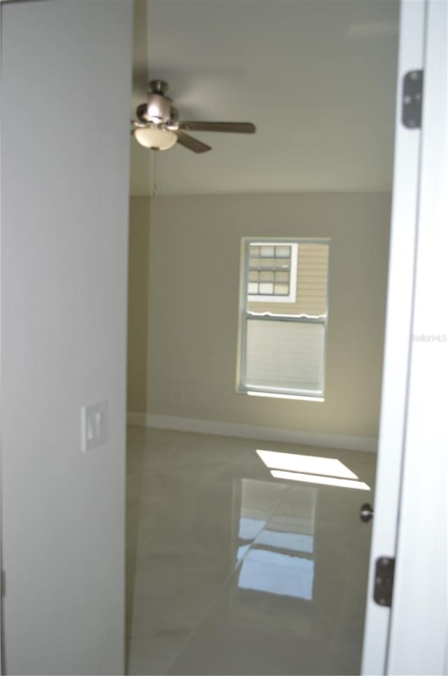 spare room featuring ceiling fan and tile flooring