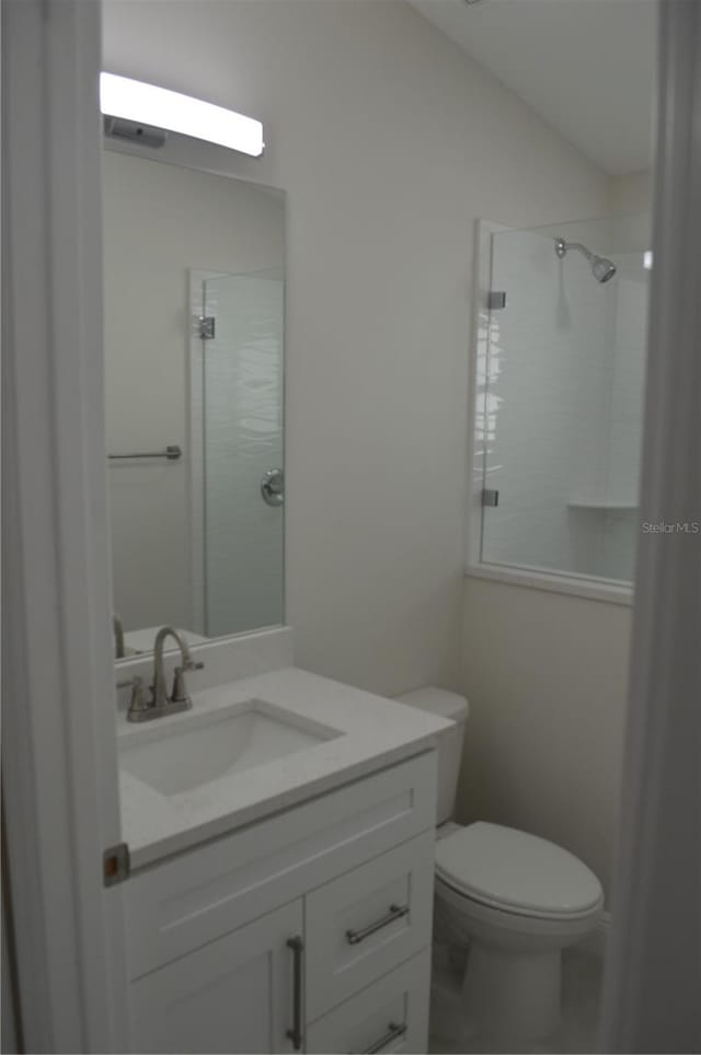 bathroom featuring walk in shower, oversized vanity, and toilet