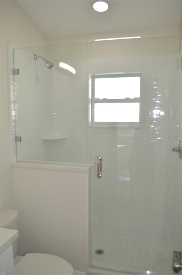 bathroom featuring an enclosed shower and toilet