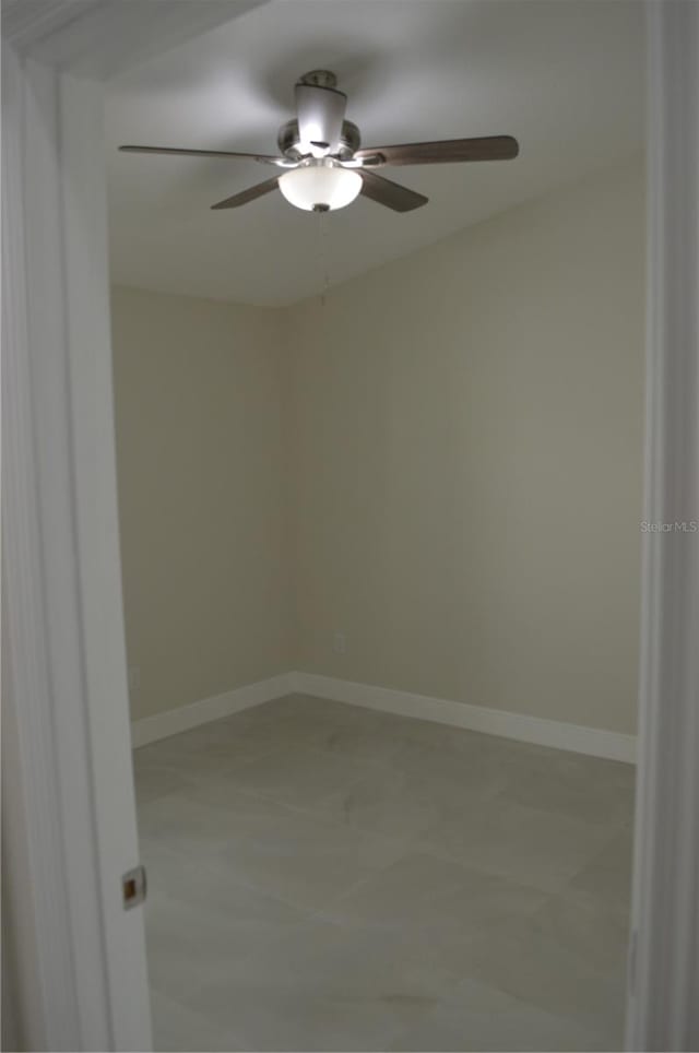 spare room featuring light tile flooring and ceiling fan