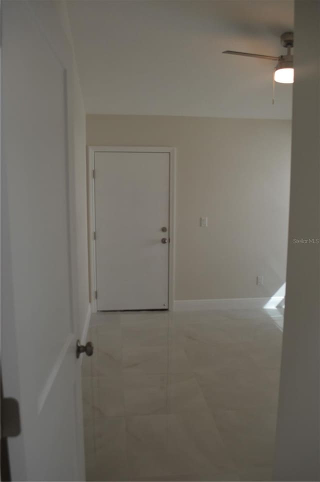 tiled spare room with ceiling fan