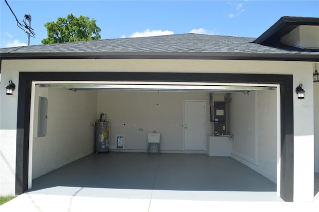 garage featuring water heater, sink, and heating utilities