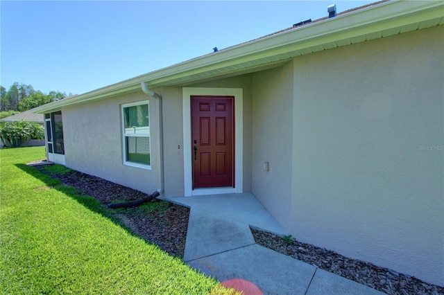 property entrance featuring a lawn