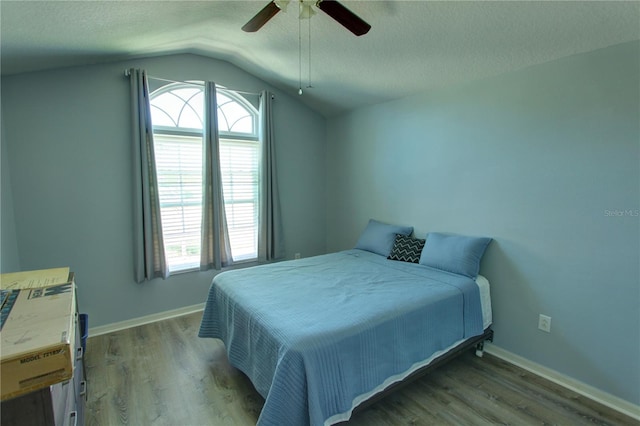 bedroom with lofted ceiling, ceiling fan, a textured ceiling, and dark hardwood / wood-style flooring