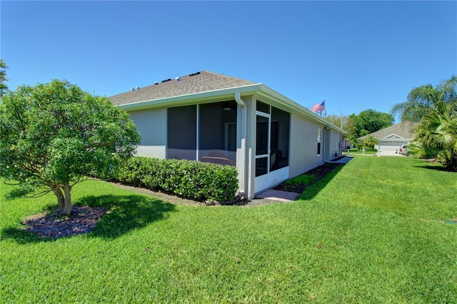 view of side of home with a sunroom and a lawn