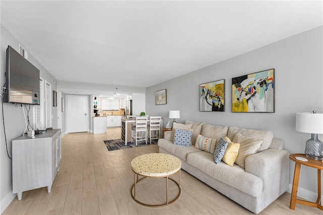 living room with light wood-style flooring and baseboards