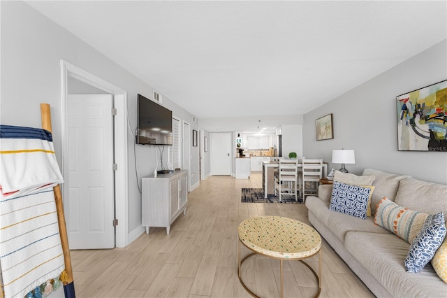 living area featuring light wood finished floors and baseboards