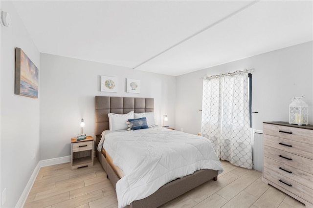 bedroom with baseboards and wood finish floors