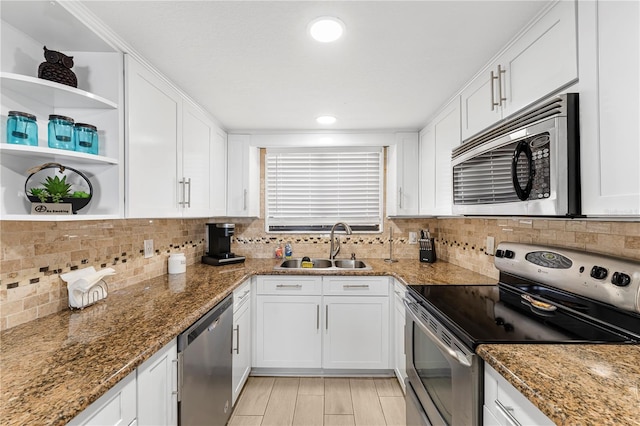 kitchen with open shelves, appliances with stainless steel finishes, a sink, and white cabinets