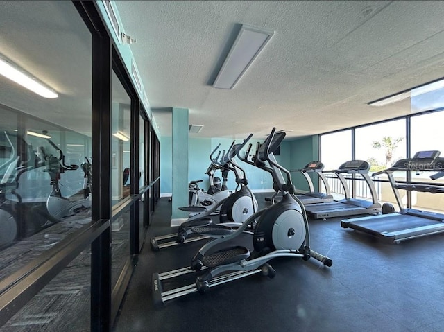 exercise room with expansive windows and a textured ceiling