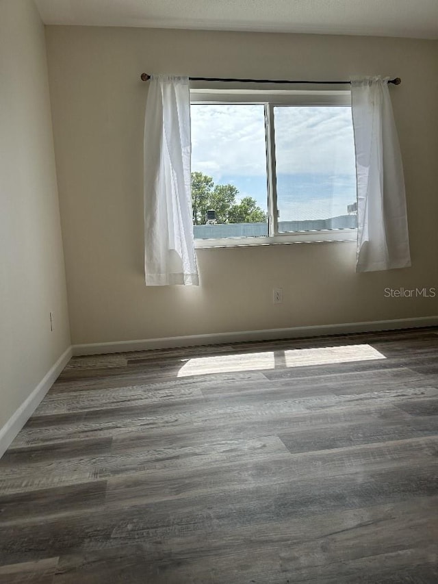 unfurnished room with dark hardwood / wood-style flooring