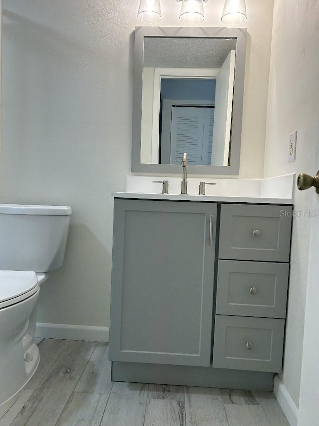 bathroom featuring vanity, hardwood / wood-style floors, and toilet