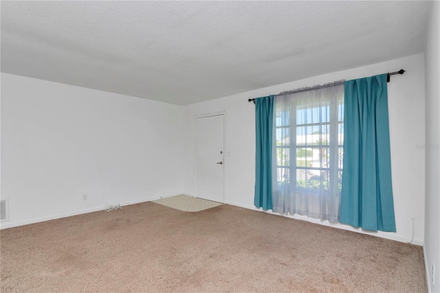 carpeted spare room featuring a textured ceiling